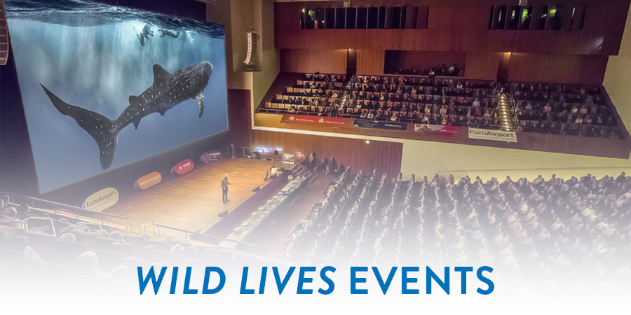 Image of Art Wolfe Speaking to the audience of people with the words Wild Lives Events on the bottom